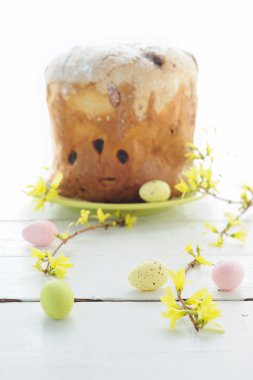 Paskalya yumurtaları, tatil pasta ve çiçekli dallar üzerinde ahşap masa