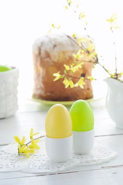 Ovos de Páscoa, bolo de férias e ramos floridos na mesa de madeira — Fotografia de Stock