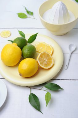 Citrus squeezer and fresh lemons being used to make fresh lemonade clipart