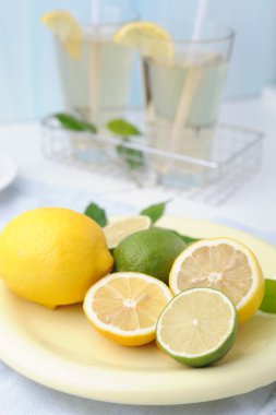 Taze limon ve limon ile kase ve iki bardak limonata Beyaz ahşap zemin üzerinde