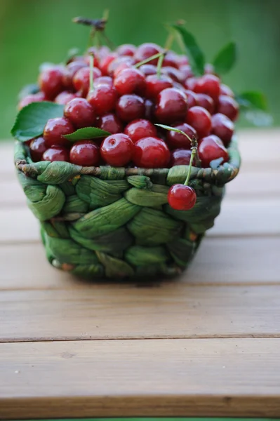 Cerejas frescas maduras em uma cesta de vime verde — Fotografia de Stock