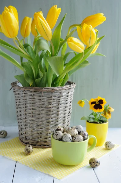 Easter holiday composition with yellow tulips on wooden table over retro background — Stock Photo, Image
