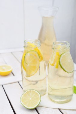 Limonata sürahi ve bardak limon ve beyaz rustik tablo kireç ile