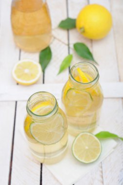 Limonata sürahi ve bardak limon ve beyaz rustik tablo kireç ile