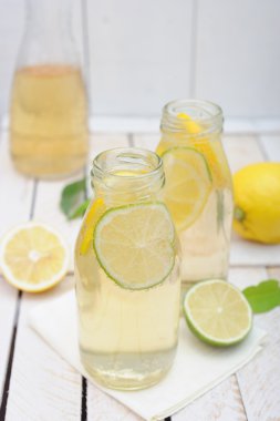 Limonata sürahi ve bardak limon ve beyaz rustik tablo kireç ile