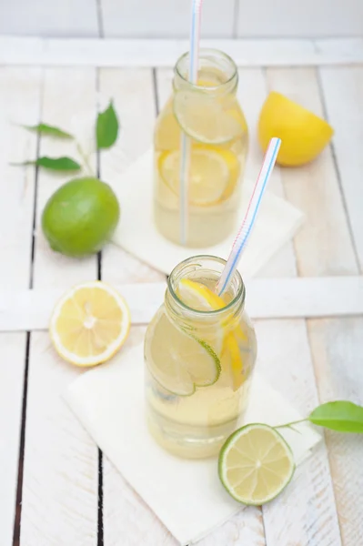 Lemonade in jar with slices of lime and lemon — Stock Photo, Image