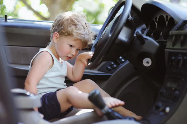 Lindo niño conduciendo padres coche — Foto de Stock