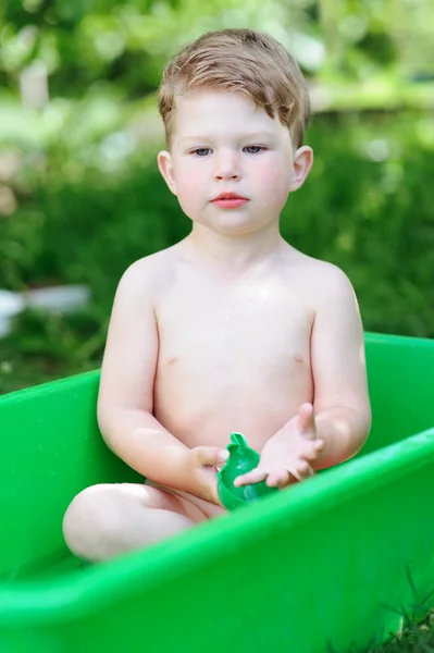 Little boy taking a bath in summer garden — Stock Photo, Image