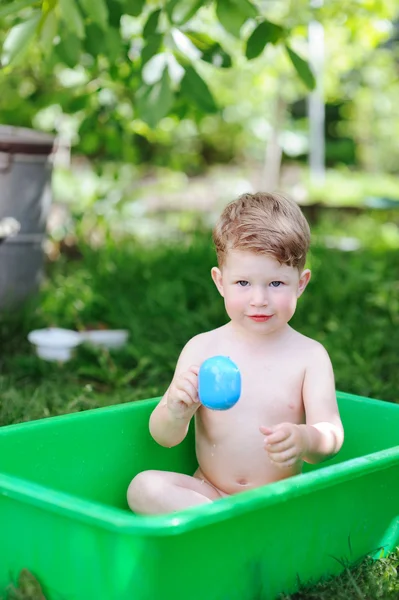 Liten pojke med ett bad i sommar trädgård — Stockfoto