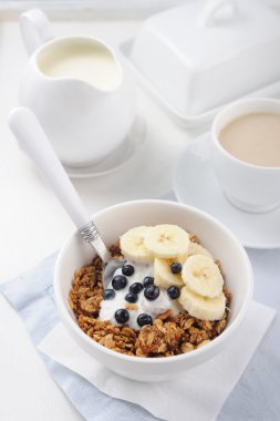 Yoğurt, taze çilek ve muz seramik kase ile bal granola