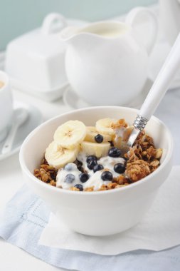 Yoğurt, taze çilek ve muz seramik kase ile bal granola