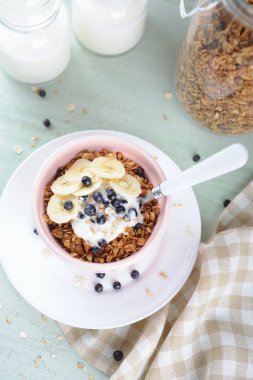 Yoğurt, taze çilek ve muz seramik kase ile bal granola
