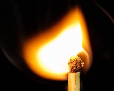 Macro - Fiamma di fiammifero ardente su sfondo nero