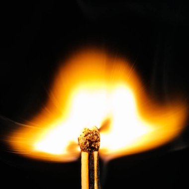 Macro - Fiamma di fiammifero ardente su sfondo nero