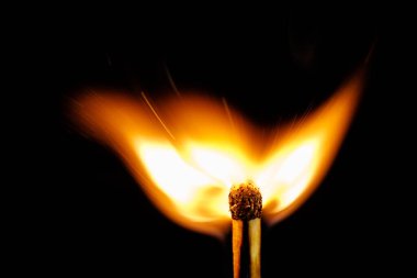 Macro - Fiamma di fiammifero ardente su sfondo nero