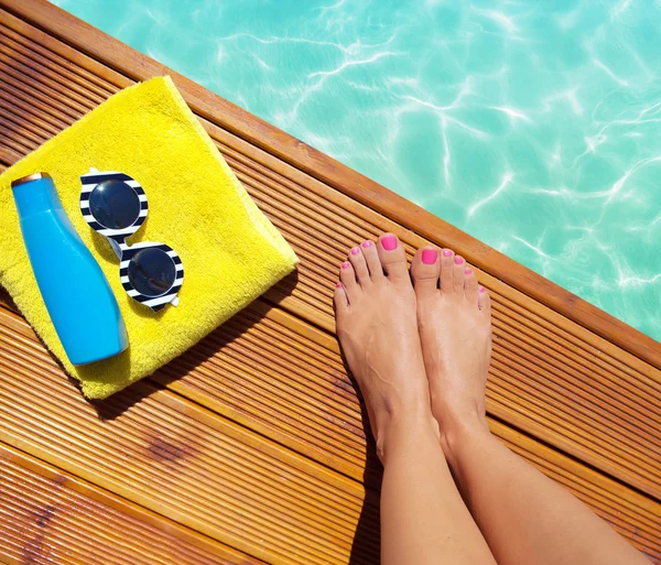 Frau auf Holzsteg am Pool mit Sommer-Accessoires — Stockfoto