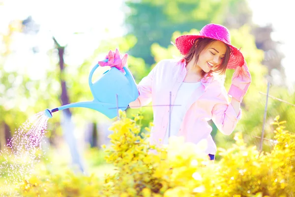 Donna con annaffiatoio in giardino — Foto Stock