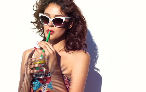 Привлекательная женщина в солнечных очках пьет воду — стоковое фото