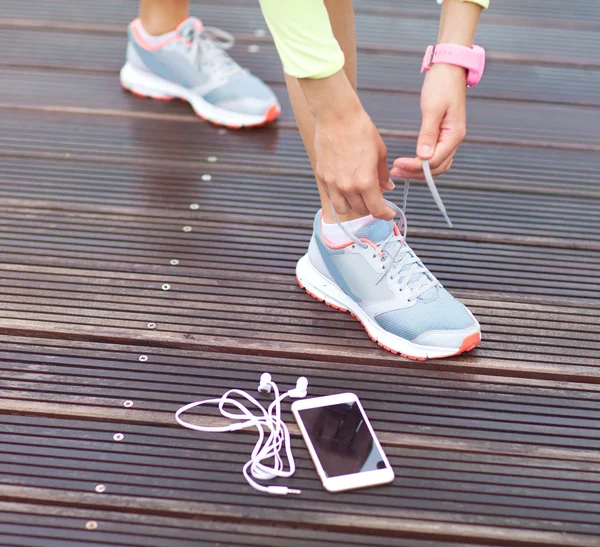 Meisje koppelverkoop running schoenen veters. — Stockfoto