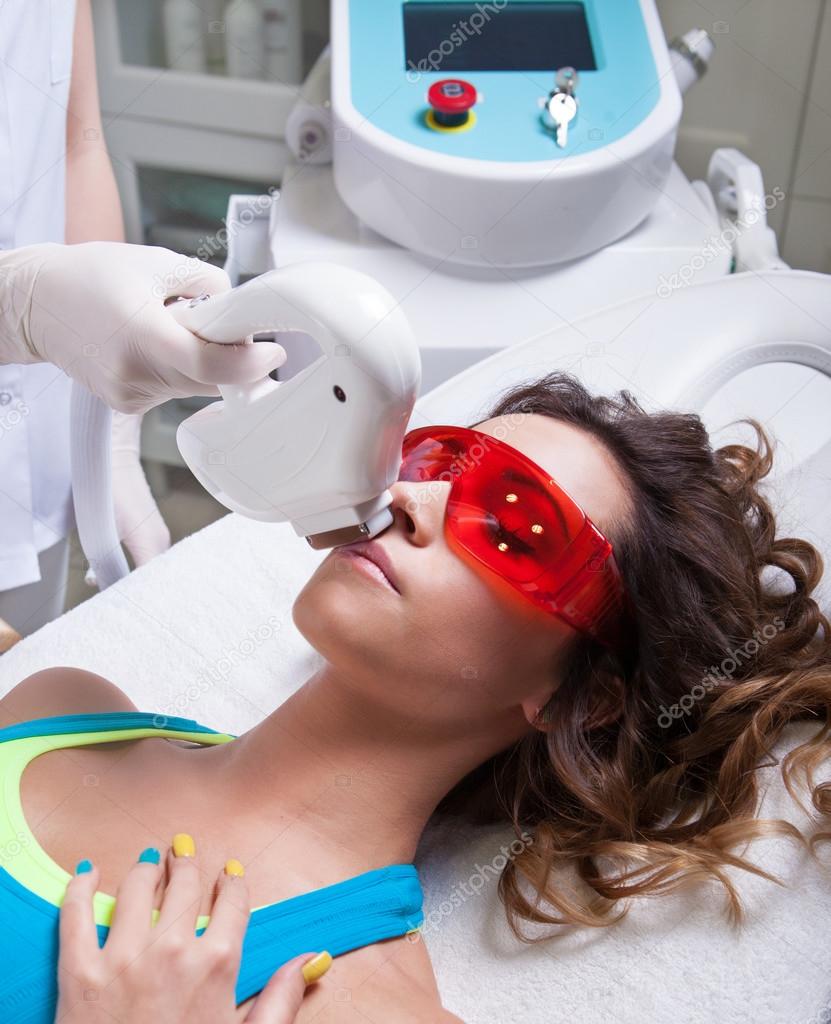 Woman getting face laser treatment Stock Photo by ©NinaMalyna 53647349