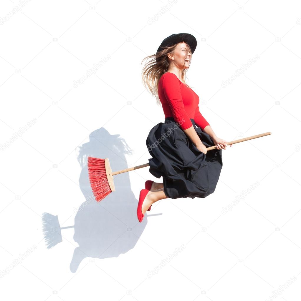 Happy young witch flying on a broom