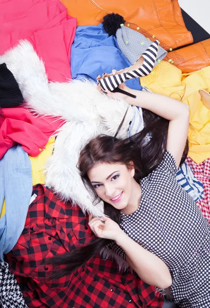 Woman lying down on a pile of clothes — Stock Photo, Image