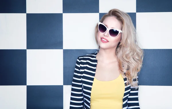 Mujer con gafas de sol sobre fondo a cuadros — Foto de Stock