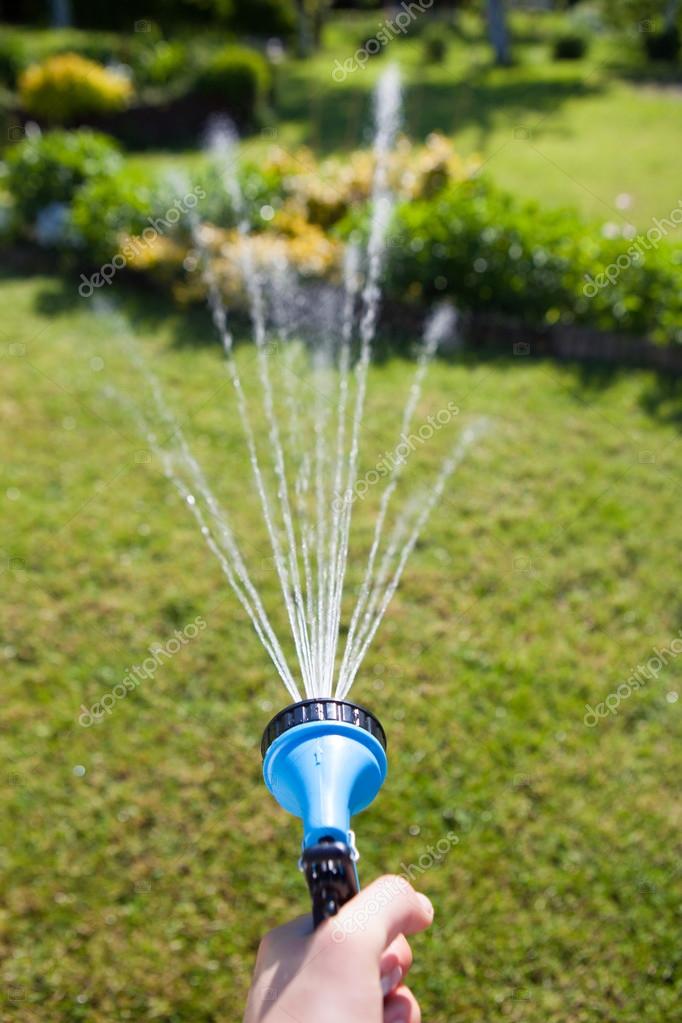 Aspersión de agua del jardín regando en el parque. — Foto de stock