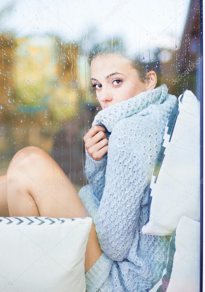 brunette woman sitting behind a window