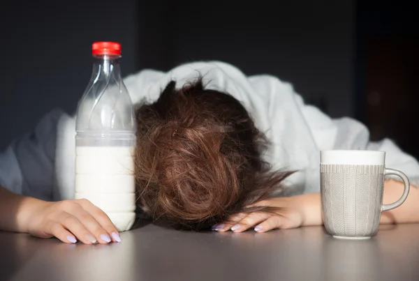 Moe vrouw met hoofd op de tafel — Stockfoto