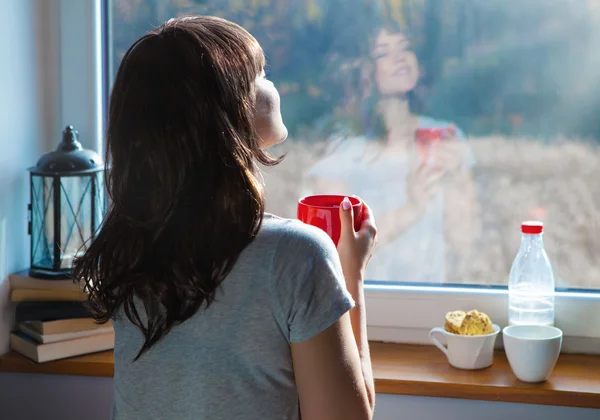 Frau mit Tasse Kaffee am Fenster — Stockfoto