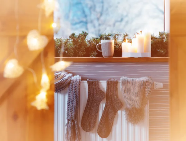 Winter fashion accessories drying on a heater — Stock Photo, Image