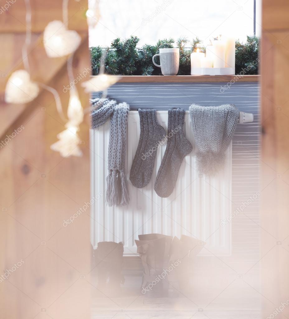 Winter boots, woolen socks drying on a heater