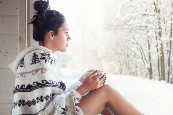 Kvinna som dricker kaffe sitta vid fönster — Stockfoto