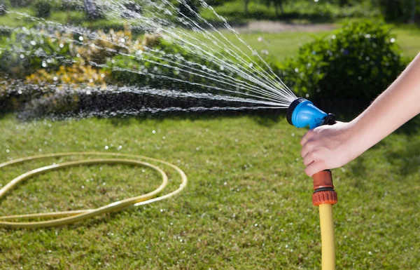 Női kéz a kerti tömlő — Stockfoto