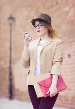 Sokakta bir akıllı telefon kullanan genç çekici kadın.