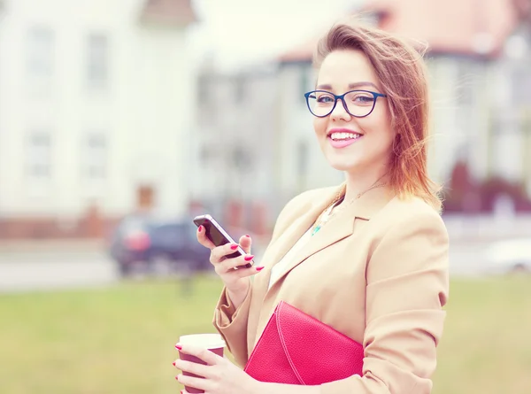 Młoda atrakcyjna kobieta przy pomocy pewien silny telefon na ulicy. — Zdjęcie stockowe