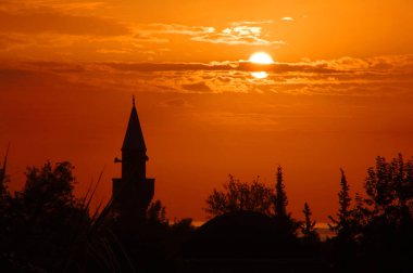 Günbatımının arkaplanındaki cami.