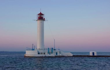 Odessa, Ukrayna, 06.21.20. Gün batımının arka planında deniz feneri manzarası.