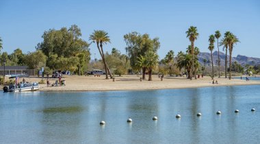 İnsanlar güneşli bir günde plajda dinleniyorlar. Havasu Gölü plajında Arizona 'da..
