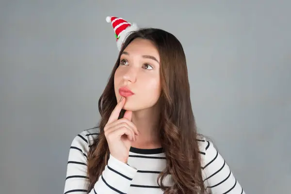 Kafasında Noel süsü olan bir kadın bir fikir düşünüyor. Yüksek kalite fotoğraf