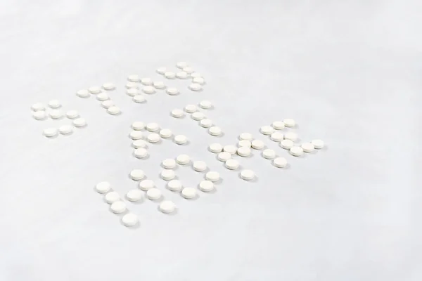 Stay at home lettering made from round white pills. Light background. High quality photo