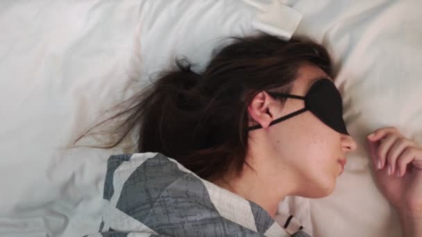 Ήρεμη Νεαρή Γυναίκα Φοράει Μάσκα Ύπνου Ενώ Ξεκουράζεται Στο Κρεβάτι — Αρχείο Βίντεο