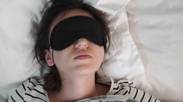 Ήρεμη Νεαρή Γυναίκα Φοράει Μάσκα Ύπνου Ενώ Ξεκουράζεται Στο Κρεβάτι — Αρχείο Βίντεο