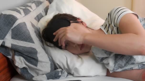 Young Woman Lies Bed Bright Day Woman Puts Sleep Mask — Vídeo de stock