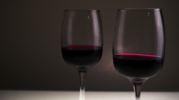 Rode Wijn Twee Glazen Een Tafel Tegen Een Donkere Achtergrond — Stockvideo