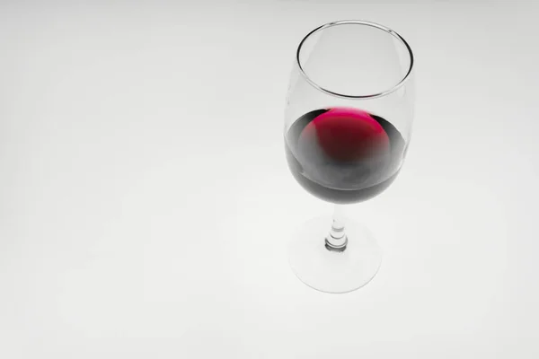 Ein Glas Rotwein auf hellem Hintergrund. — Stockfoto