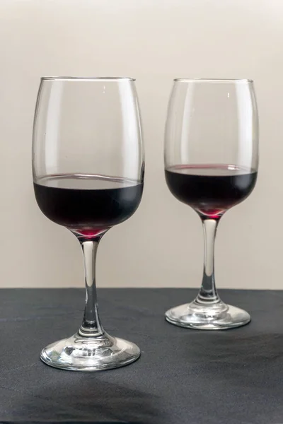 Zwei Gläser Rotwein auf verschwommenem homogenem Hintergrund. — Stockfoto