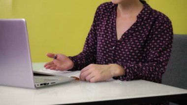 Genç bir melez kadın evde oturuyor ve bir dizüstü bilgisayarla meşgul..