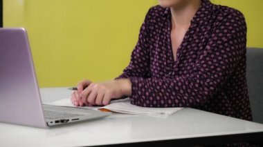 Genç bir melez kadın evde oturuyor ve bir dizüstü bilgisayarla meşgul..